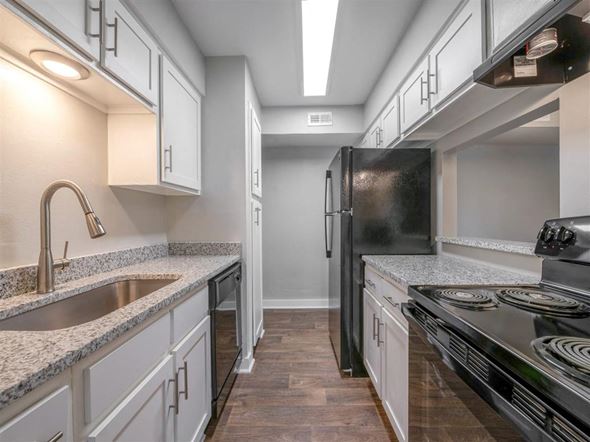 Indianapolis apartment for rent - a kitchen with white cabinets and a black refrigerator