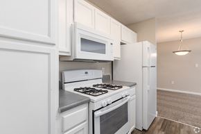 Acworth apartment for rent - a kitchen with white cabinets and appliances and a white refrigerator