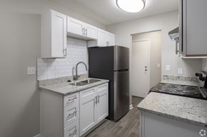Augusta apartment for rent - A kitchen with white cabinets and a black refrigerator.