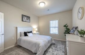 Lexington apartment for rent - A bedroom with a white bed and a grey rug.