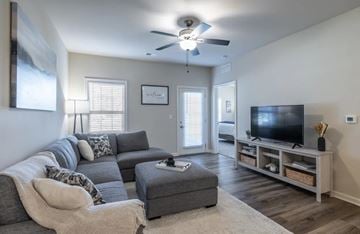 Lexington apartment for rent - A living room with a grey couch and a television on a wooden stand.