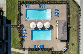 Lexington apartment for rent - A pool surrounded by a black fence and blue lounge chairs.
