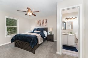 High Point apartment for rent - A bedroom with a bed, nightstand, and a ceiling fan.