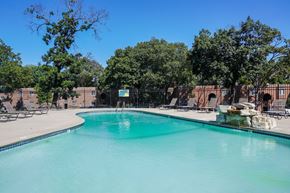 Kansas City apartment for rent - A swimming pool surrounded by trees and chairs.
