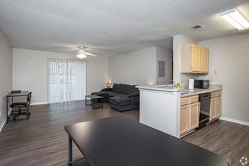 Macon apartment for rent - A kitchen with a table and a couch in the living room.
