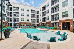 Marietta apartment for rent - an empty swimming pool with blue chairs in front of an apartment building