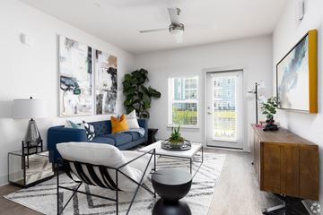 Orlando apartment for rent - A living room with a blue couch and a white chair.