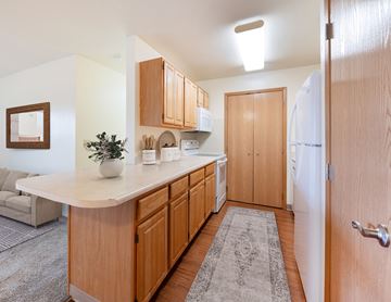 Grimes apartment for rent - A kitchen with wooden cabinets and a white countertop.