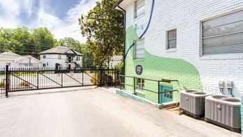 A green and white brick building with a green mural on the side of it and a black