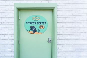 A green door with a sign that says the oasis fitness center