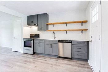 A kitchen with gray cabinets and white walls