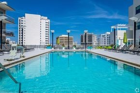 Sarasota apartment for rent - A large swimming pool in a city setting with buildings in the background.
