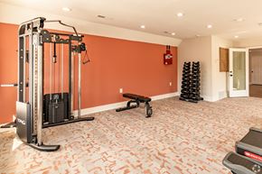 Shawnee Mission apartment for rent - a home gym with a red wall and exercise equipment