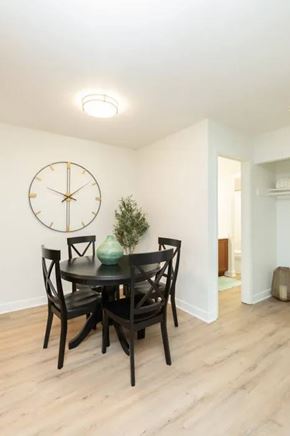 Madison apartment for rent - A dining room with a round table and chairs and a clock on the wall.