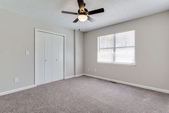 Vacant bedroom with closet and natural light