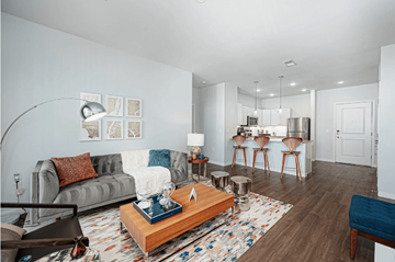 Columbus apartment for rent - A living room with a grey couch, a wooden coffee table, and a rug with a blue cushion.