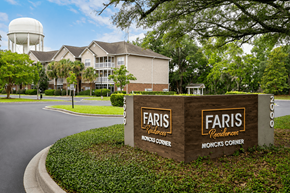 Moncks Corner apartment for rent - A sign for Faris Residences Moncks Corner stands in front of a building.