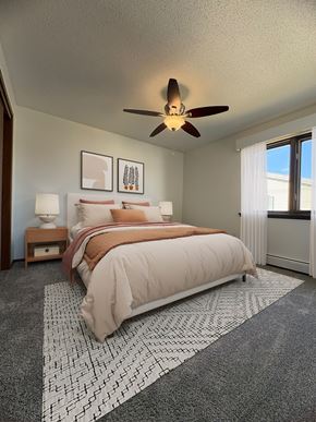 West Des Moines apartment for rent - A bedroom with a large bed and a ceiling fan.