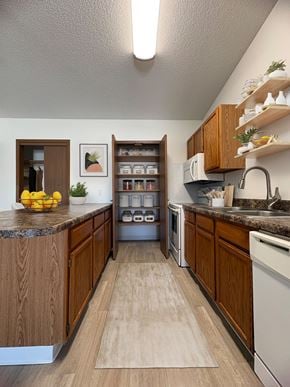 West Des Moines apartment for rent - A kitchen with wooden cabinets and a countertop with a bowl of lemons on it.
