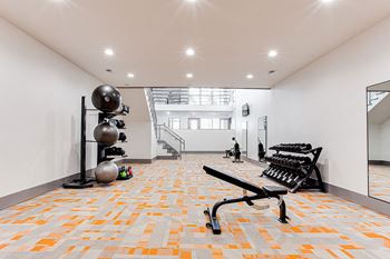 A gym with orange and grey tiles on the floor