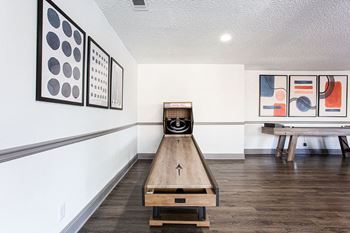 A room with a bowling alley and artwork on the wall
