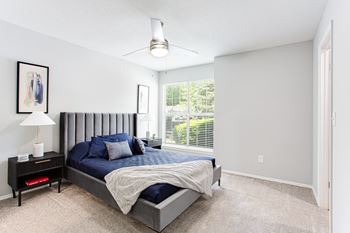 A bedroom with a bed and a large window