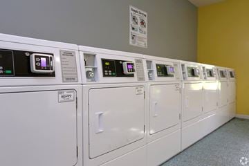 Frisco apartment for rent - A row of washing machines are lined up in a laundromat.