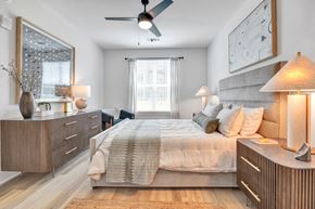 Huntsville apartment for rent - A bedroom with a bed, nightstands, and a ceiling fan.