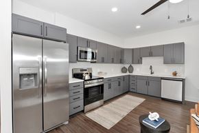 Huntsville apartment for rent - A modern kitchen with a stainless steel refrigerator and wooden flooring.