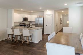 Kingsport townhouse for rent - a kitchen and dining room with white cabinets and stainless steel appliances
