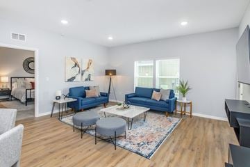 Ocala triplex for rent - A living room with a blue couch and a rug.