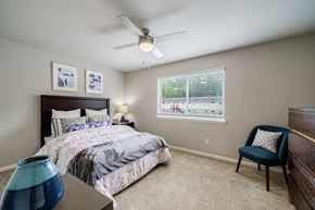Atlanta apartment for rent - A bedroom with a bed, chair, and ceiling fan.