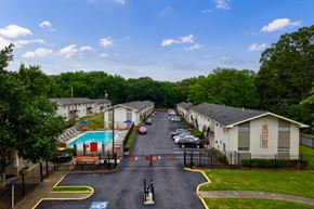 Atlanta apartment for rent - A view of a road with apartment buildings on either side and a pool in the middle.