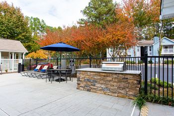 A patio with a table and chairs and a blue umbrella