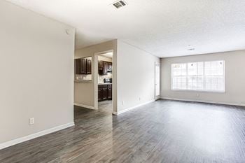 A spacious room with wood flooring and a large window