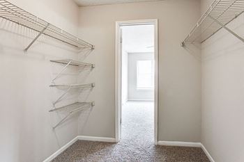 A hallway with a carpeted floor and a doorway leading to another room