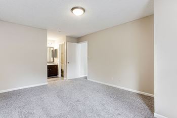 A room with a carpeted floor and a doorway leading to another room