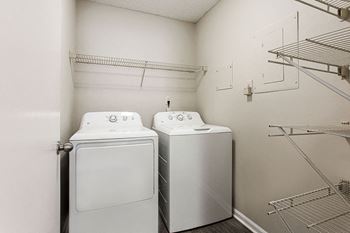 Two white washing machines in a laundry room