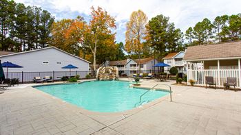 A swimming pool surrounded by a patio and trees