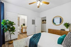 Beaufort apartment for rent - A bedroom with a bed, a ceiling fan, and a mirror on the wall.