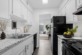 Savannah apartment for rent - A modern kitchen with a black refrigerator and white cabinets.