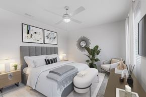 Savannah apartment for rent - A bedroom with a large bed, a ceiling fan, and a plant.