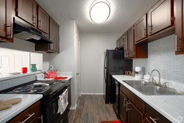 Burleson apartment for rent - A kitchen with black appliances and wooden cabinets.