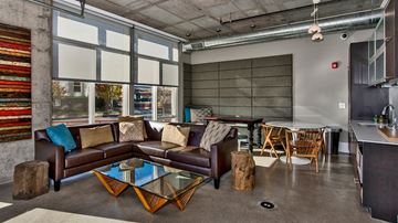 Denver apartment for rent - A living room with a brown couch and a glass coffee table.
