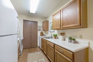 Altoona apartment for rent - A kitchen with wooden cabinets and a white fridge.