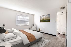 Prairie Village apartment for rent - A bedroom with a large bed and a painting on the wall.