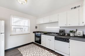 Prairie Village apartment for rent - A kitchen with white cabinets and black countertops.