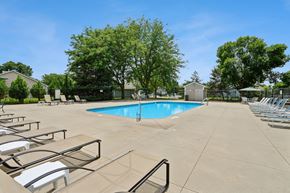 Altoona apartment for rent - A large swimming pool surrounded by sun loungers and trees.