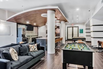 Dallas apartment for rent - A game room with a foosball table and a couch.