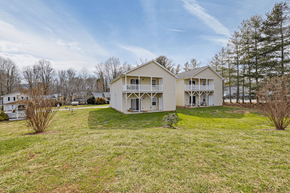 Asheville apartment for rent - a white house with a yard and trees in the background